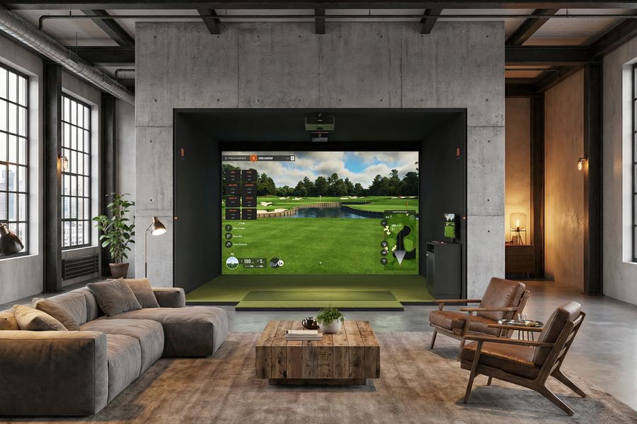Loft-style simulator room with a concrete enclosure, sectional sofa and leather chairs