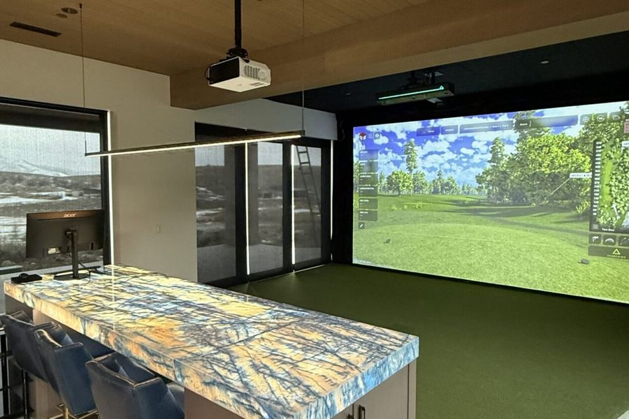 Simulator bay opening onto a kitchen island with bar seating